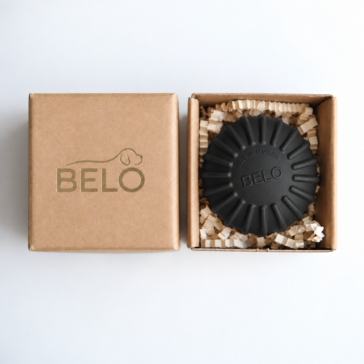 Midnight black BELO Aero Ball dog toy in an open cardboard box beside the branded lid