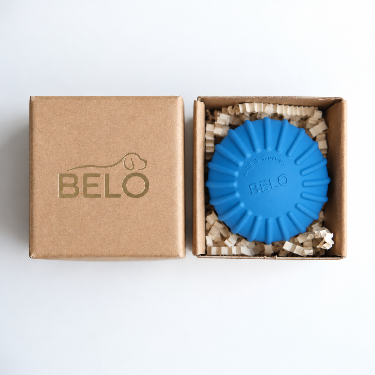Sky blue BELO Aero Ball dog toy in an open cardboard box beside the branded lid
