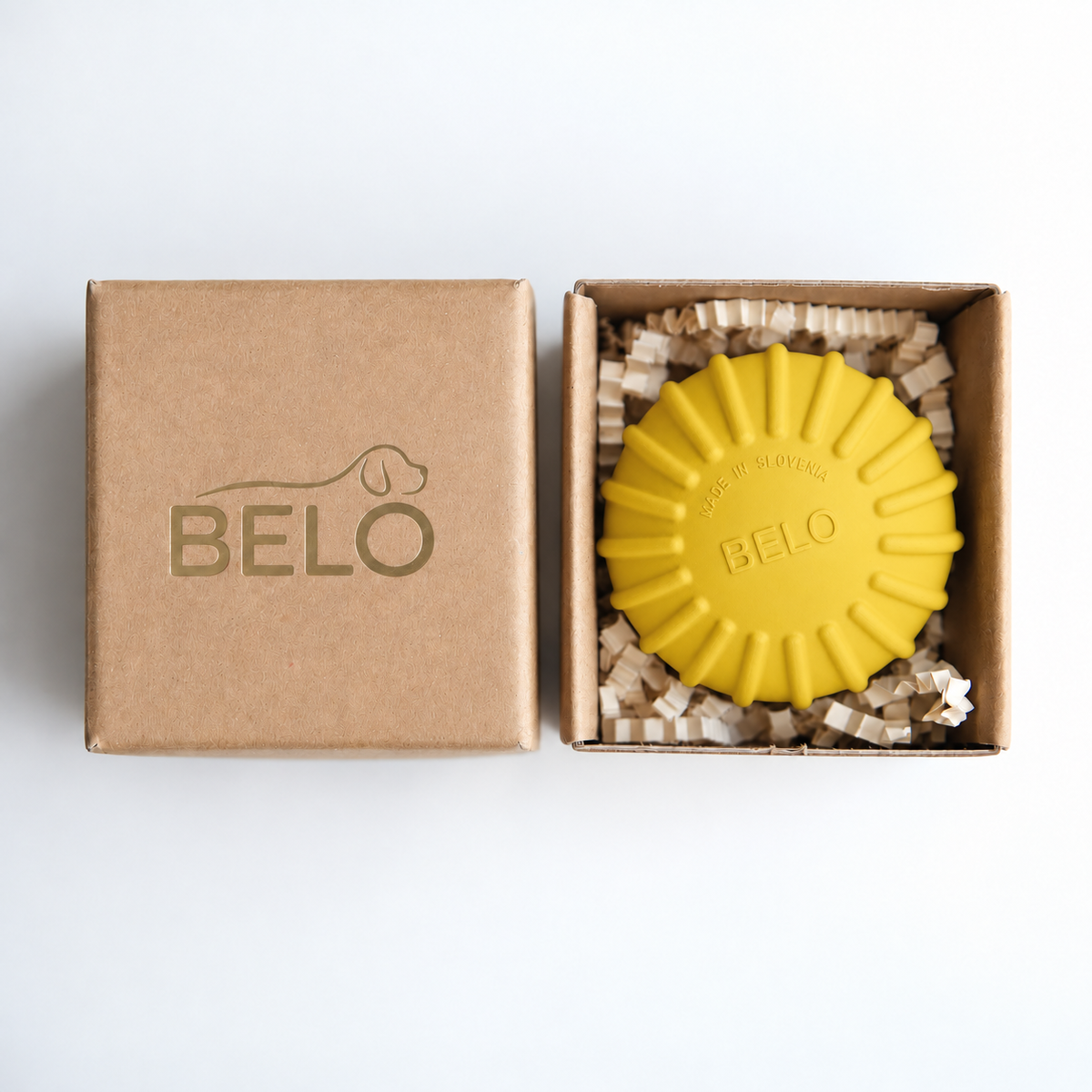 Sunshine yellow BELO Aero Ball dog toy in an open cardboard box beside the branded lid